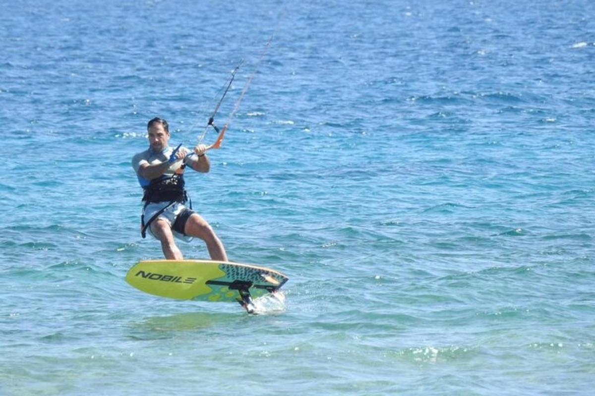 um homem em pé em uma prancha de surfe na água
