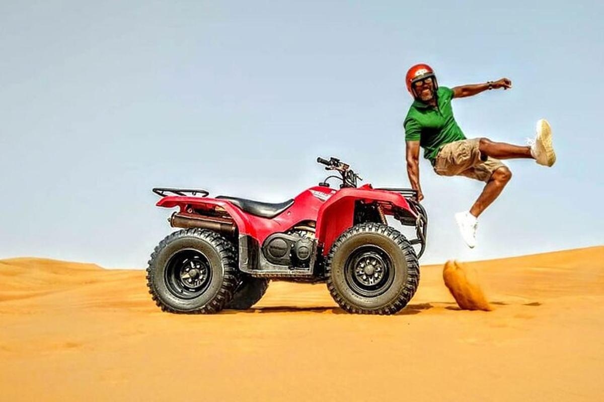 a man jumping in the air next to a atv in the desert