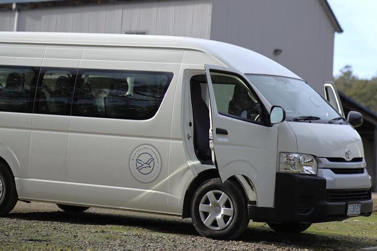 een witte bestelwagen geparkeerd naast een gebouw
