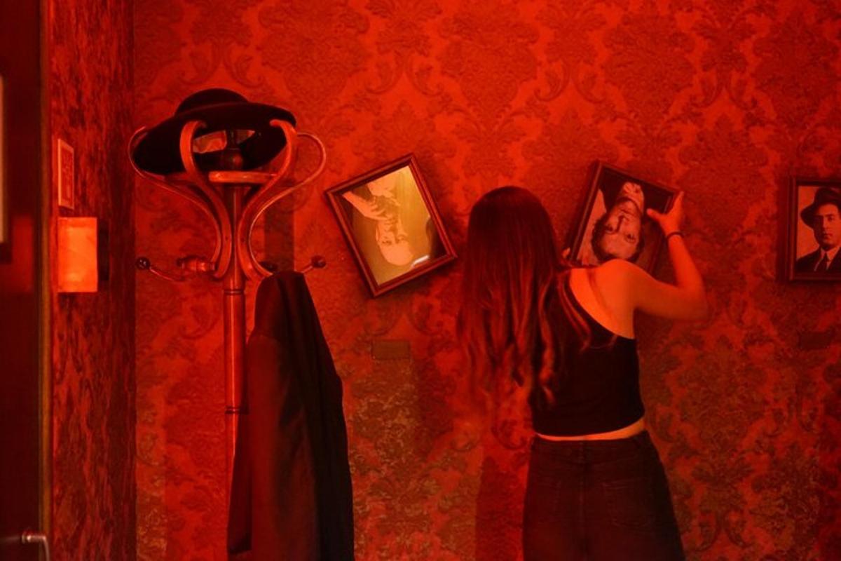 Una mujer tomándose una foto en una pared roja.