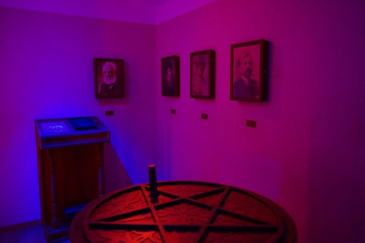Una habitación morada con una mesa y cuadros en la pared.