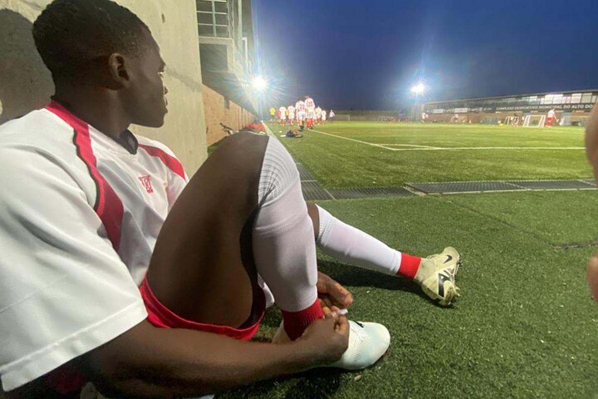 un uomo seduto su un campo da calcio di notte