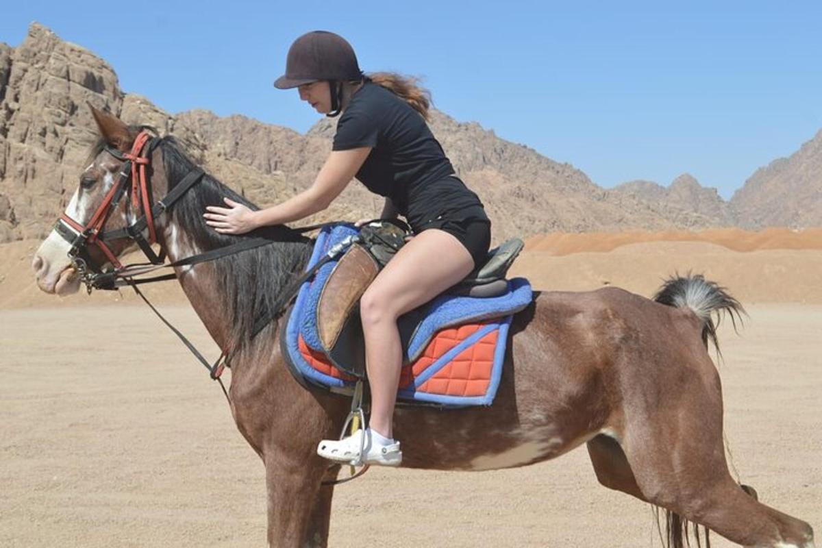 una mujer montando a caballo en el desierto