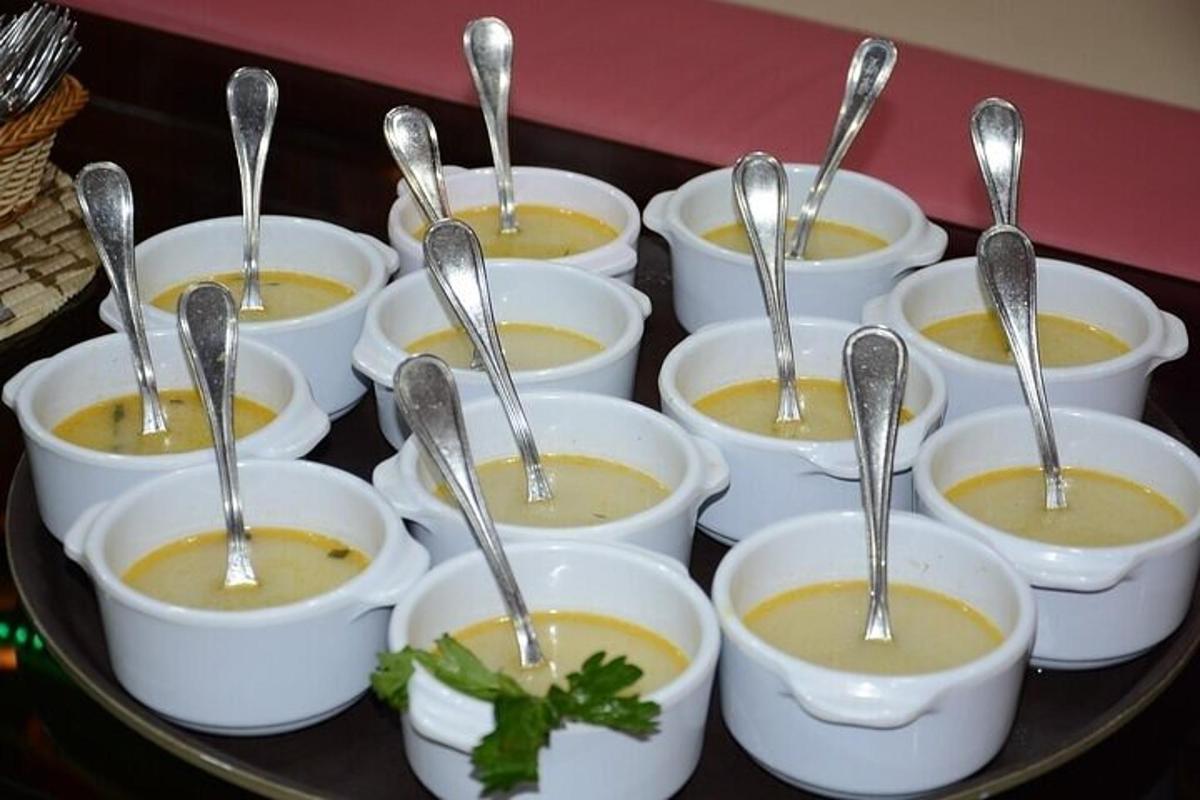 um monte de tigelas de sopa com colheres dentro