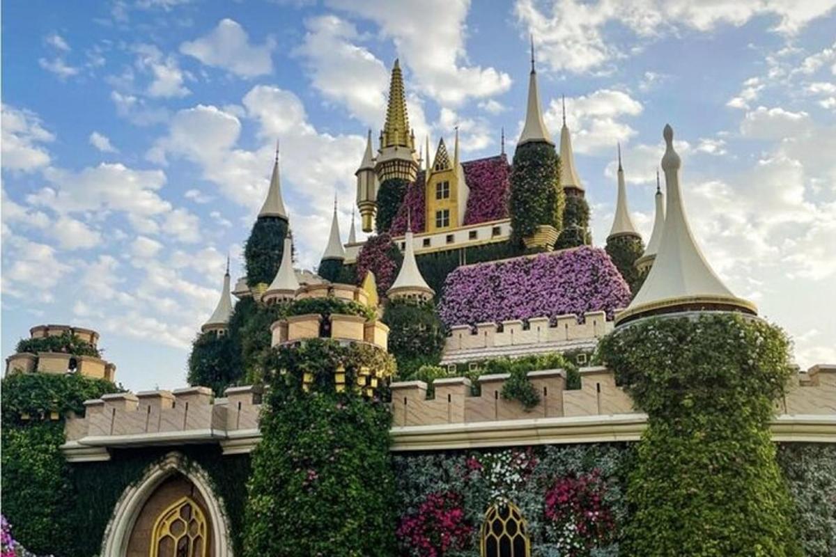 a castle in the middle of a park with flowers
