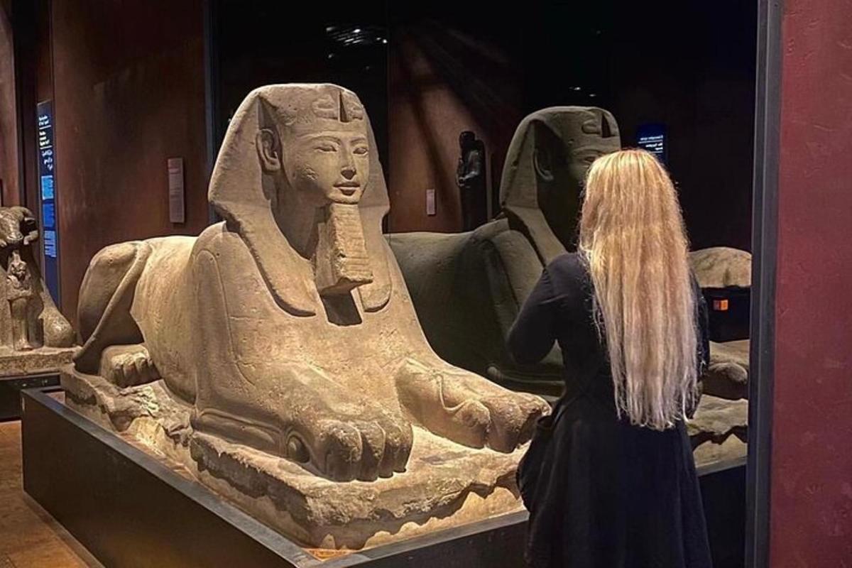a woman standing in front of a statue in a museum