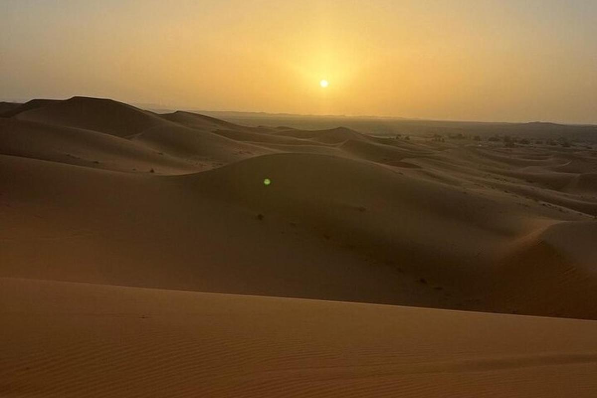 un deserto con il sole che tramonta sulle dune di sabbia