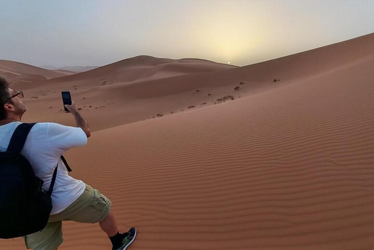 un uomo che scatta una foto del deserto con il suo cellulare