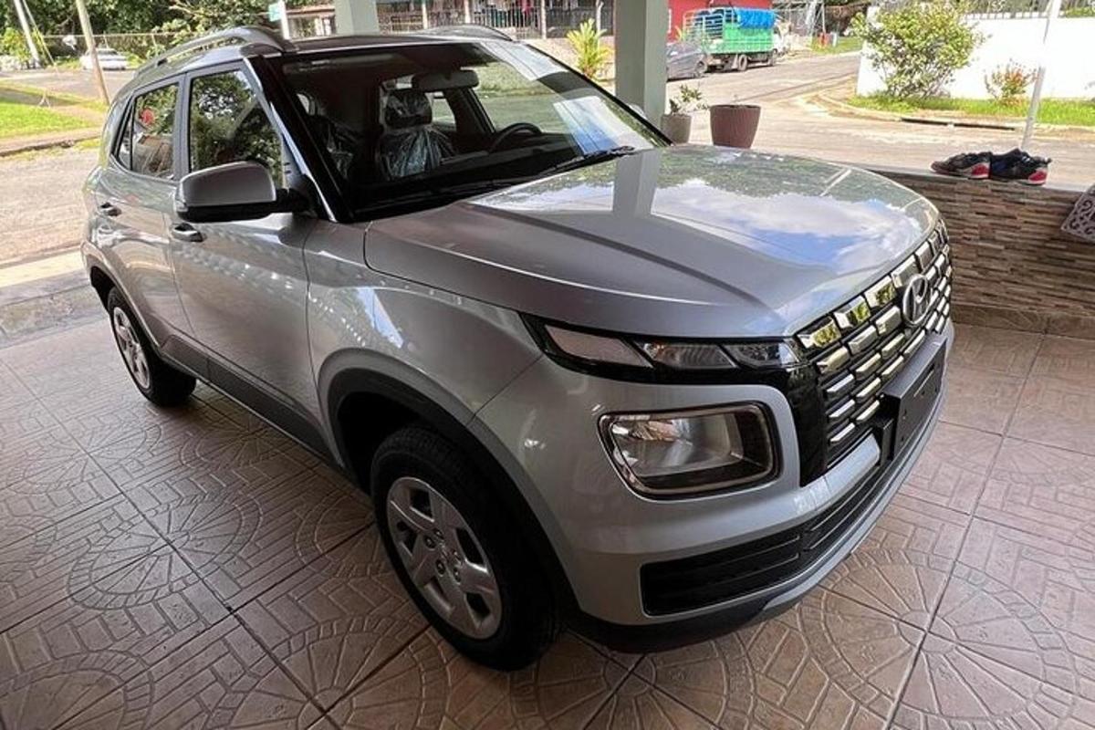 a silver suv is parked on a sidewalk