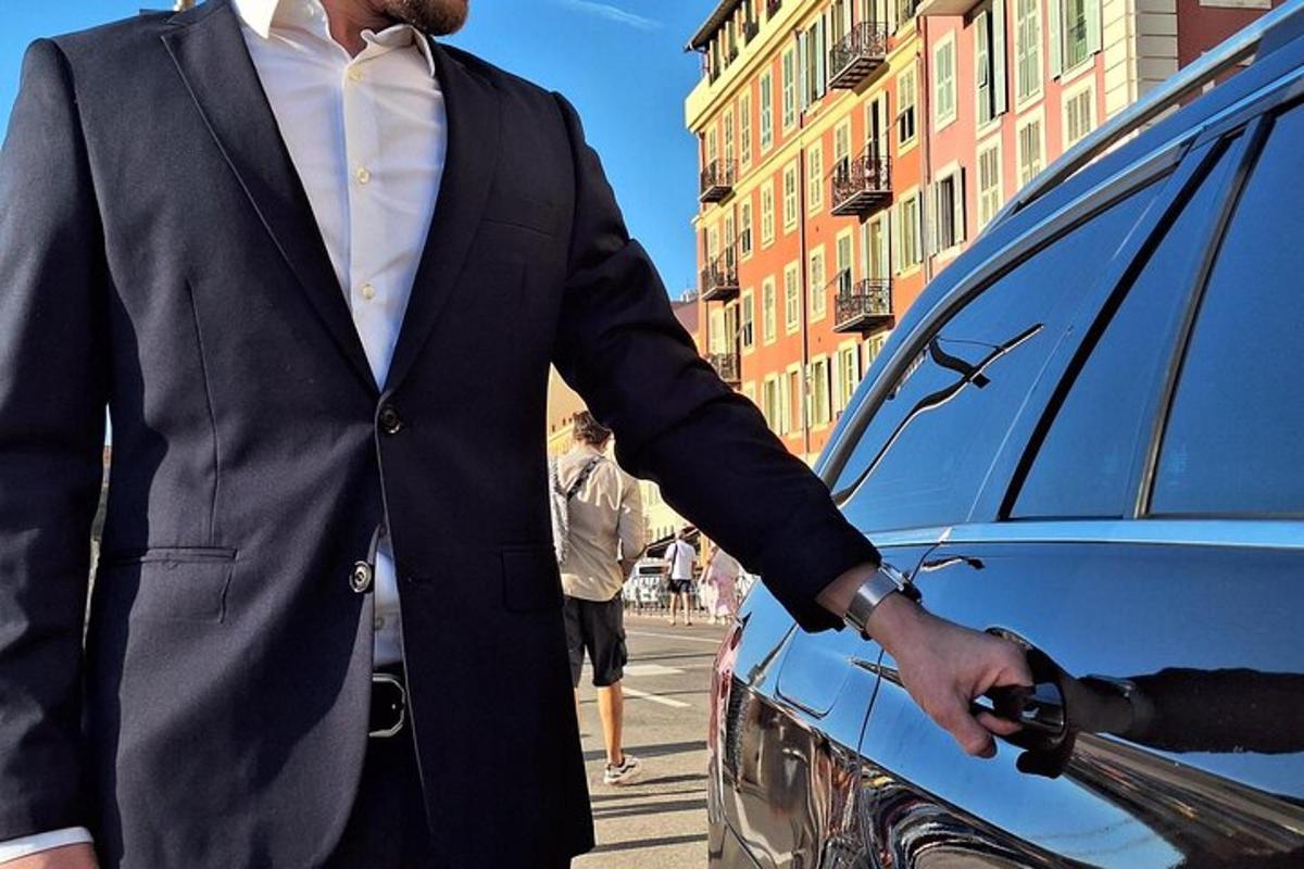 un uomo in giacca e cravatta in piedi accanto a un'auto