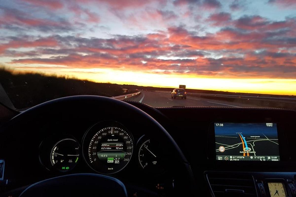 una vista di un'auto che percorre un'autostrada al tramonto