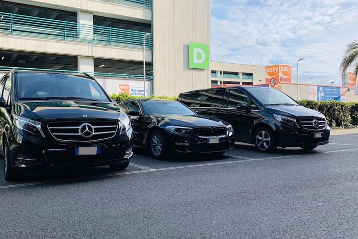 tři auta zaparkovaná na parkovišti před budovou