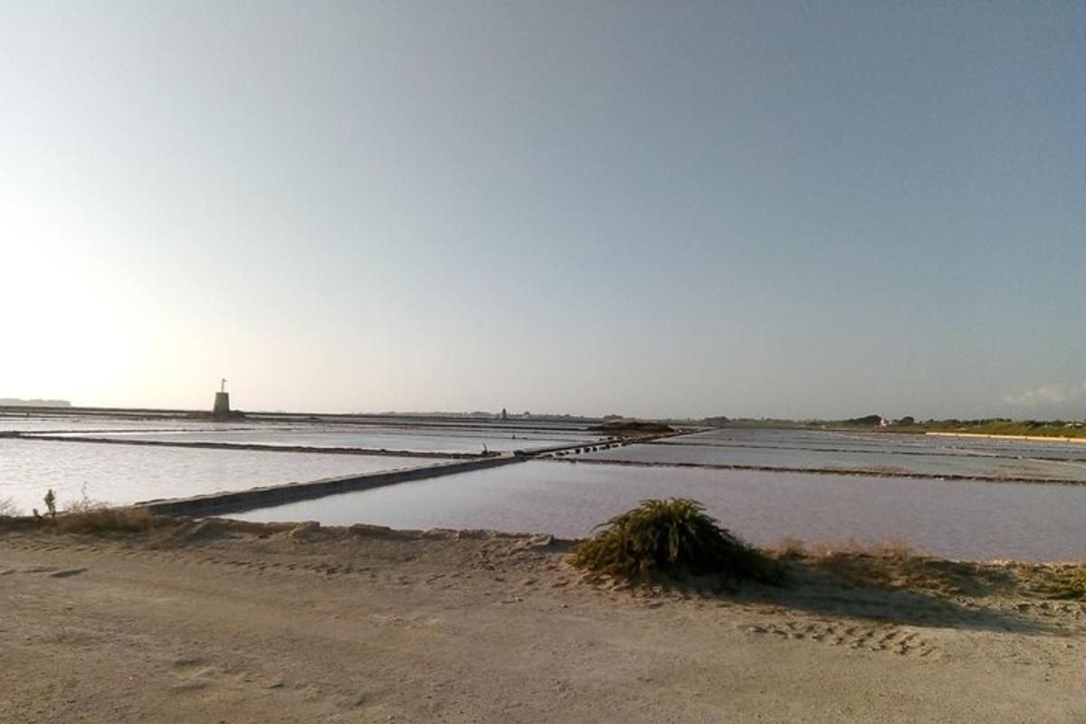 uno specchio d'acqua con un faro sullo sfondo