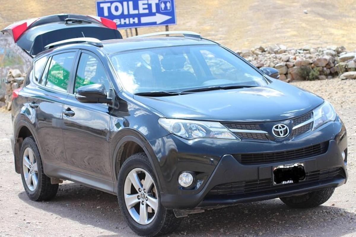 una Toyota blu con una tavola da surf sul tetto