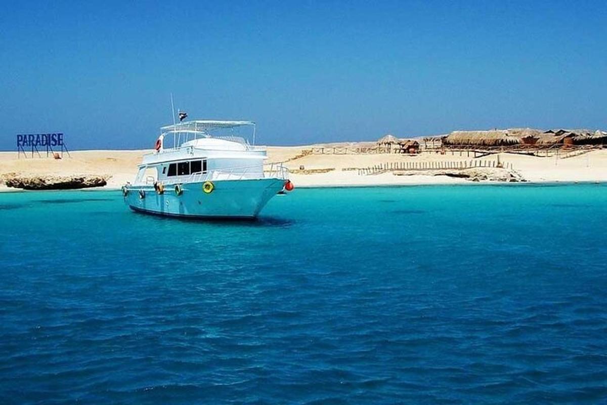 un bateau bleu dans l'eau à côté d'une plage