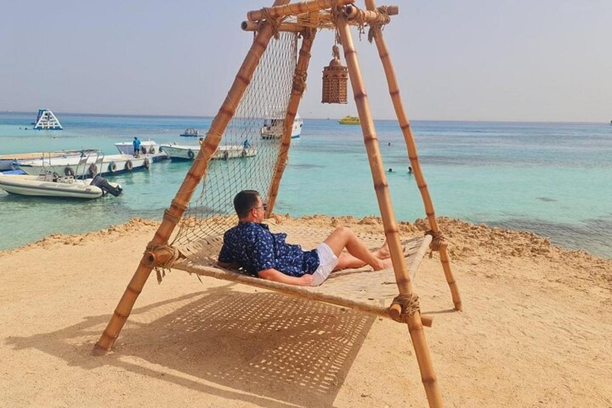 un homme assis sur une balançoire sur une plage
