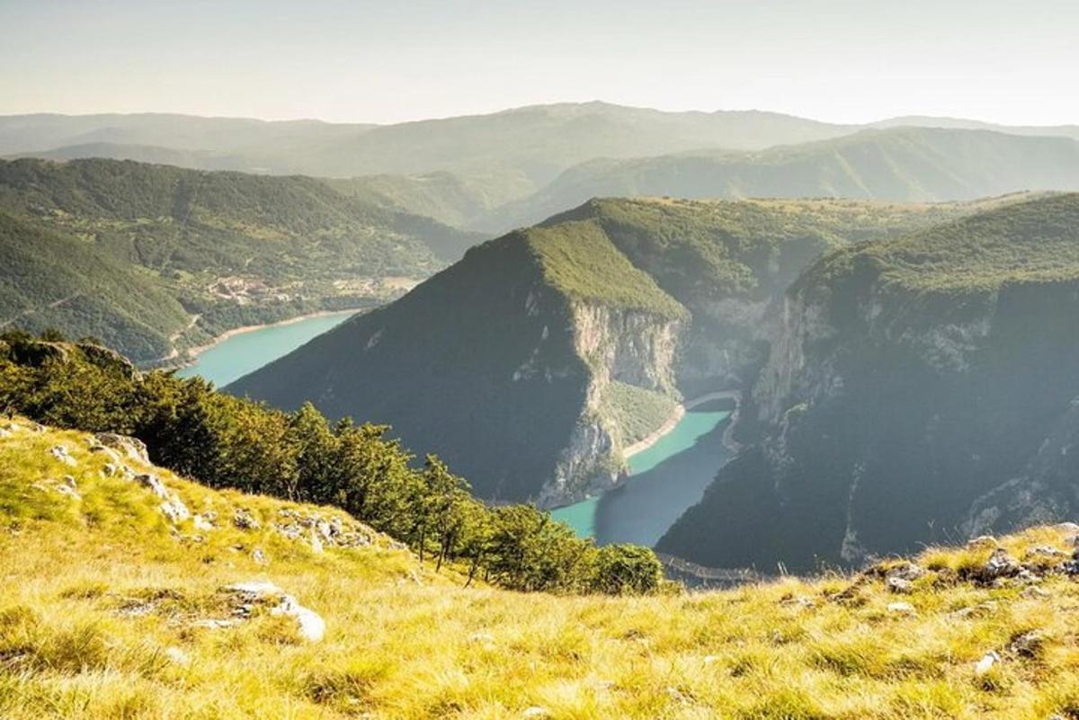 μια θέα μιας κοιλάδας με μια λίμνη στα βουνά