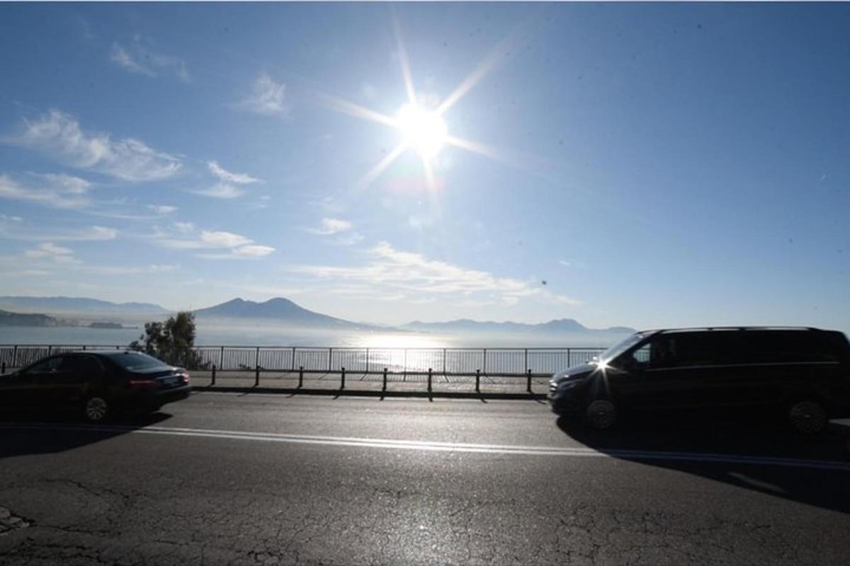kaks autot pargitud parklas, päike paistab taevas