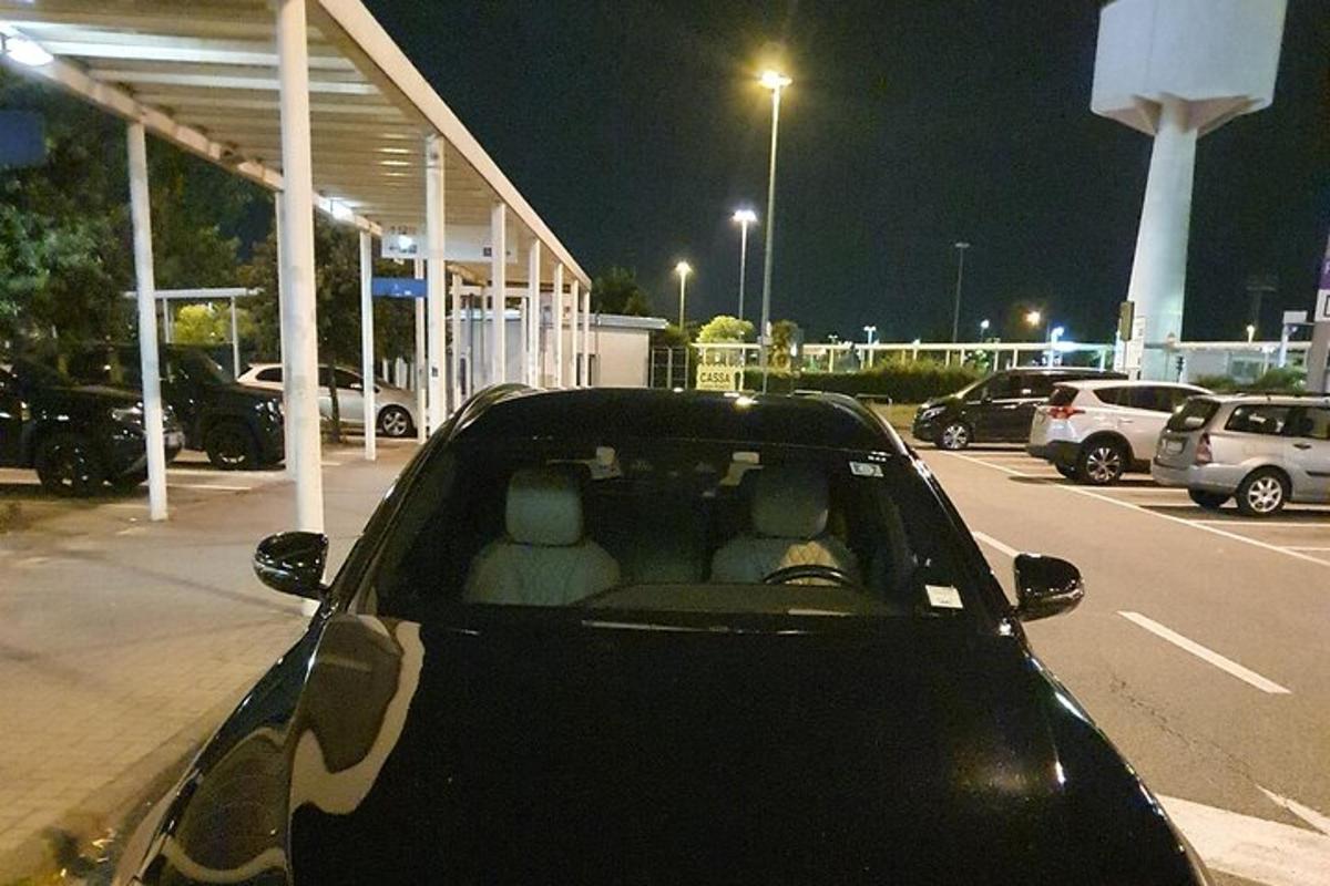 een zwarte auto geparkeerd op een parkeerplaats 's nachts