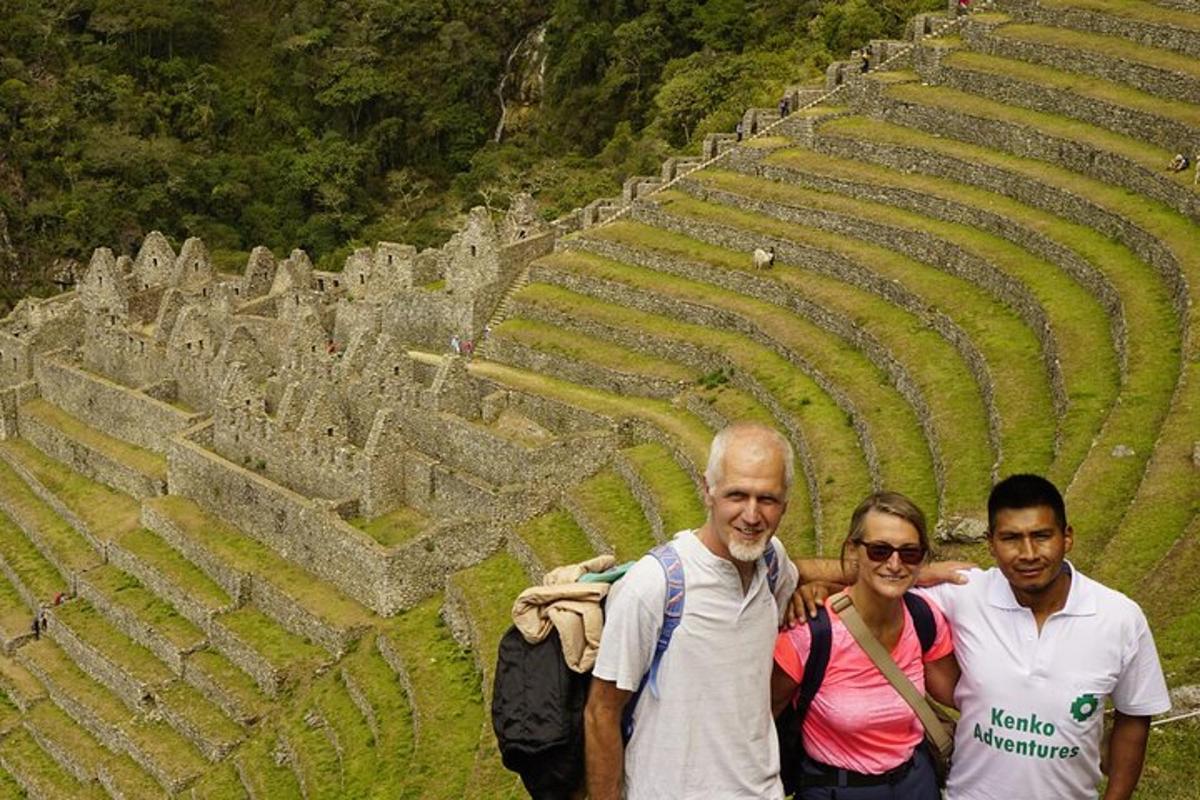 Dos hombres y una mujer de pie frente a un anfiteatro.