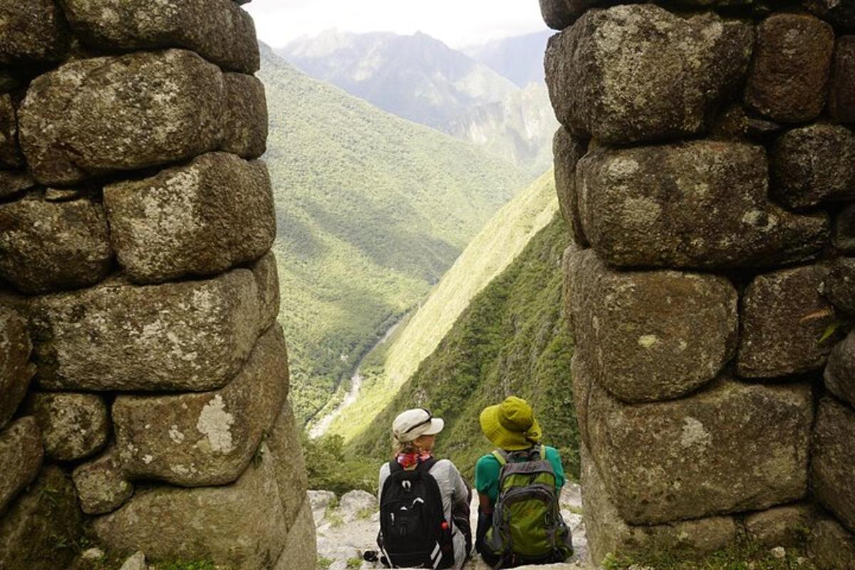 due persone in piedi su una montagna che guardano una valle
