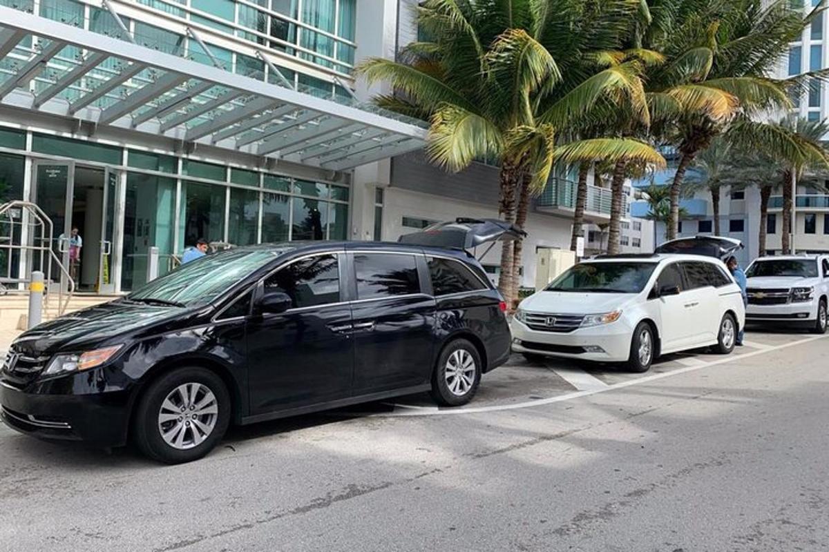 two cars parked in front of a building with palm trees