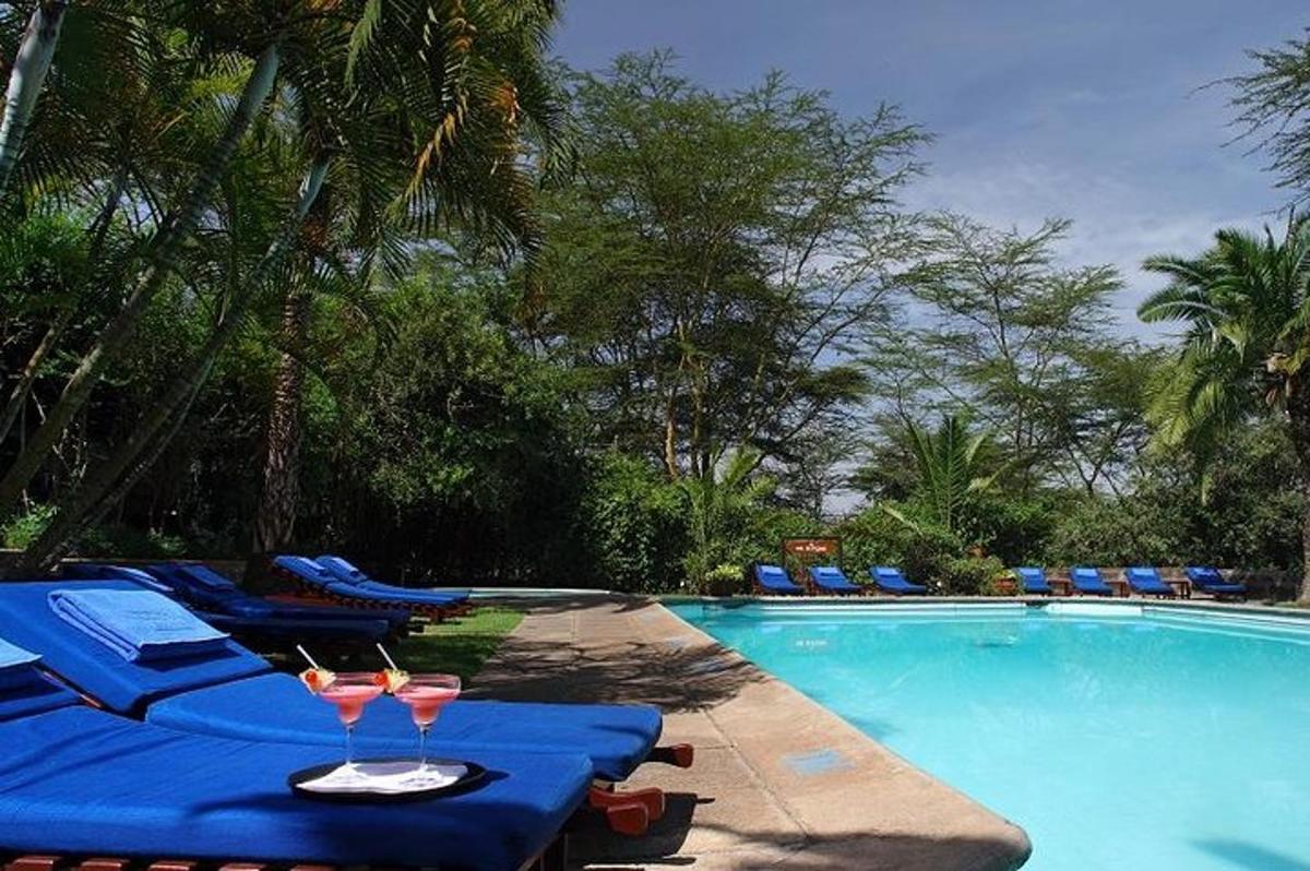 una piscina con dos mesas y dos copas de vino