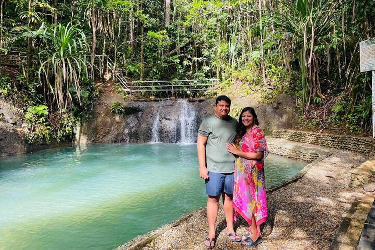 a man and a woman standing in front of a waterfall