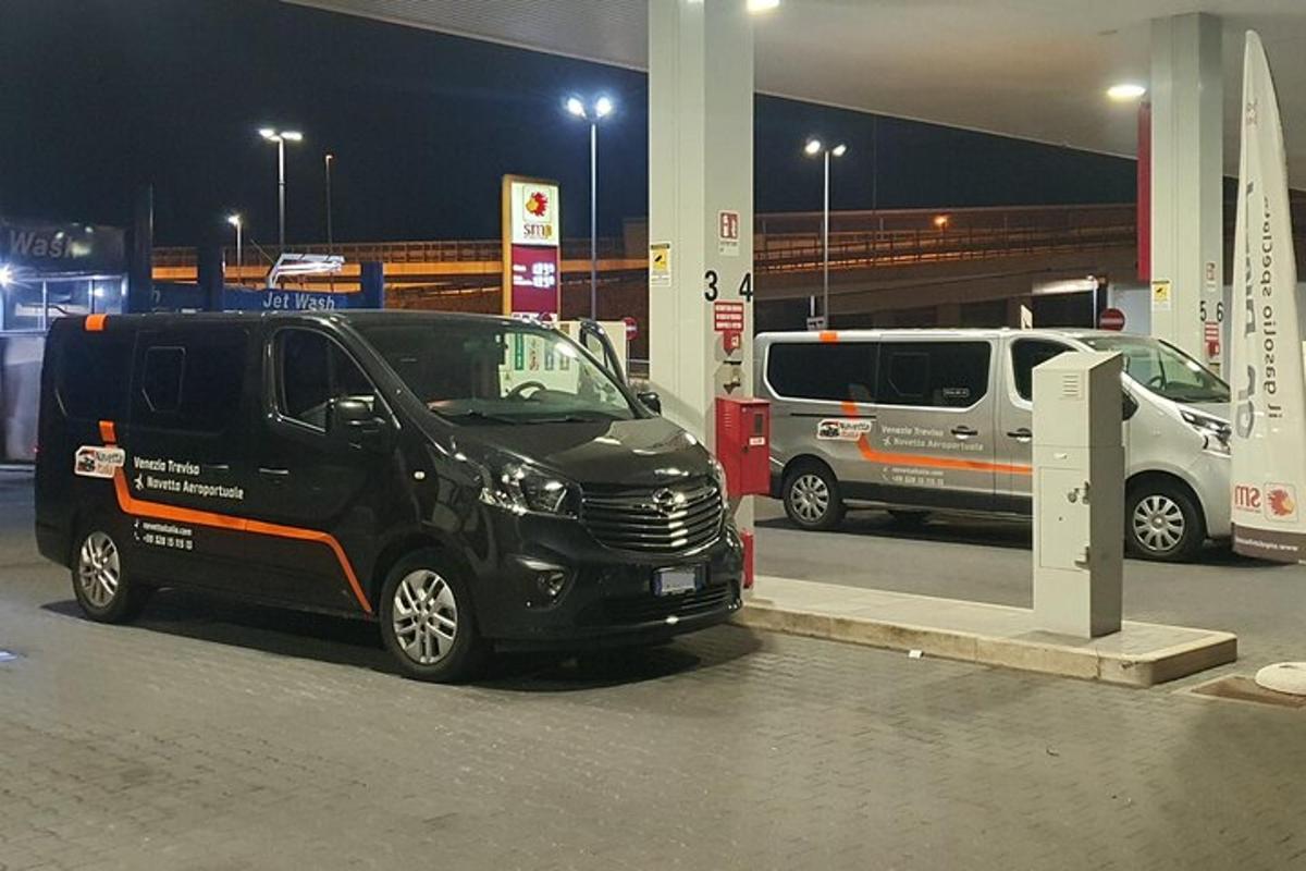 un furgone nero parcheggiato in una stazione di servizio di notte