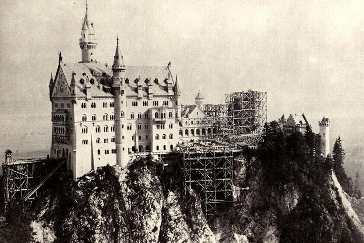 een oude foto van een kasteel op een berg