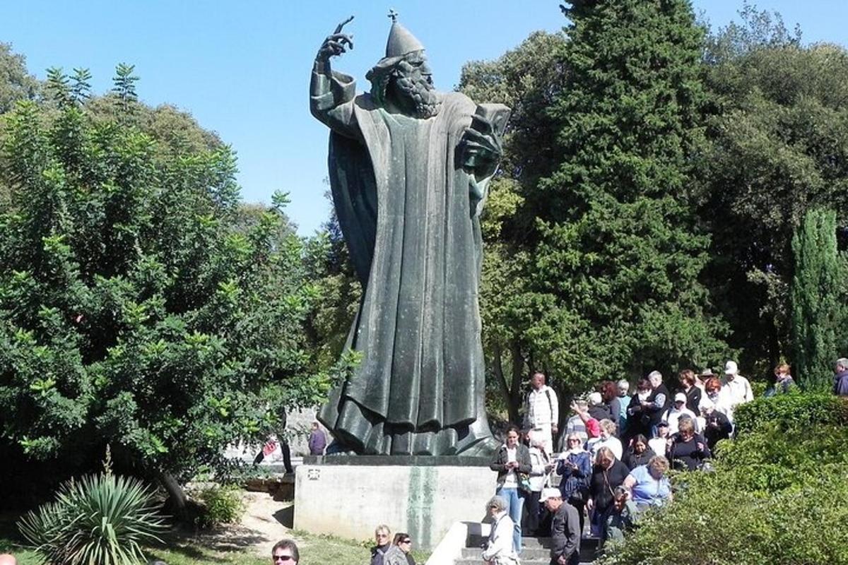 skupina lidí stojící kolem sochy