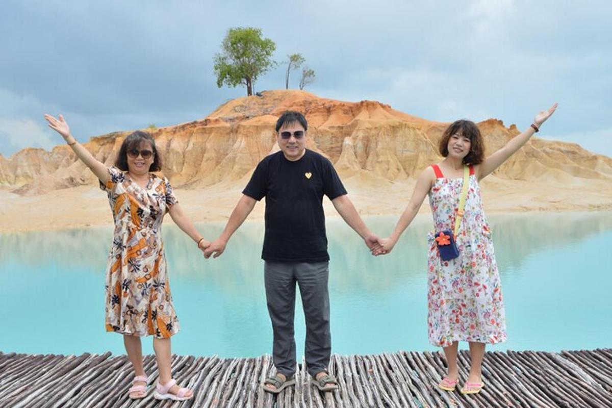 a man and two women standing in front of a body of water