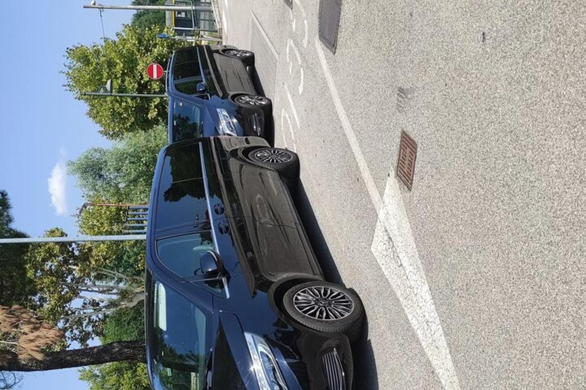 kaksi sinistä autoa pysäköitynä rakennuksen viereen