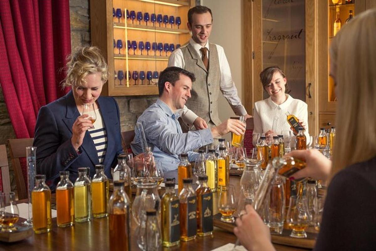 skupina lidí sedících kolem stolu s lahvemi alkoholu
