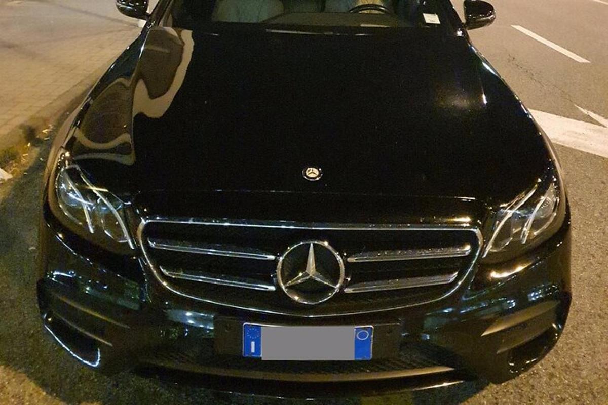 sebuah kereta mercedes benz berhenti di tepi jalan