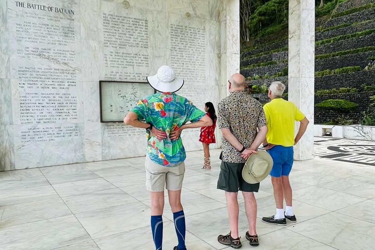 un gruppo di persone in piedi davanti a un monumento ai caduti