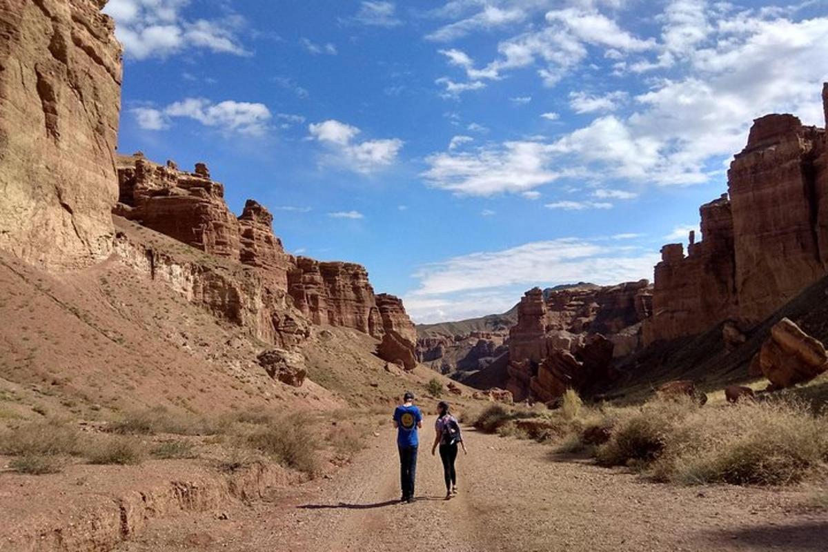 due persone che camminano lungo una strada sterrata attraverso un canyon