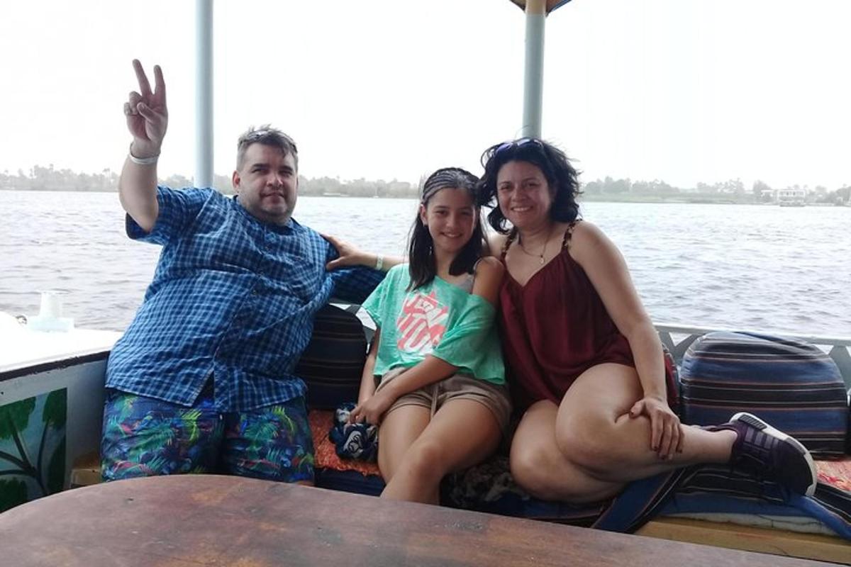 isang grupo ng tatlong tao na nakaupo sa isang bangka