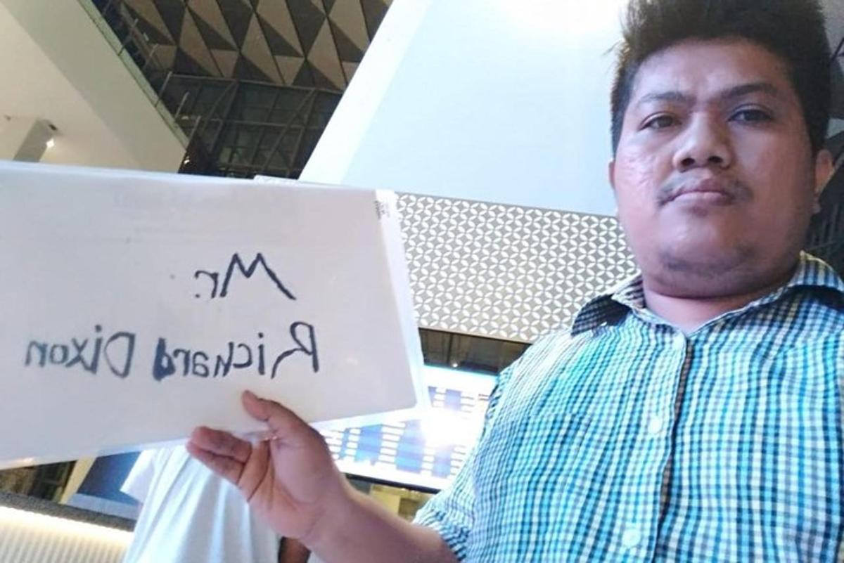 muž držící ceduli s nápisem mg honolulu