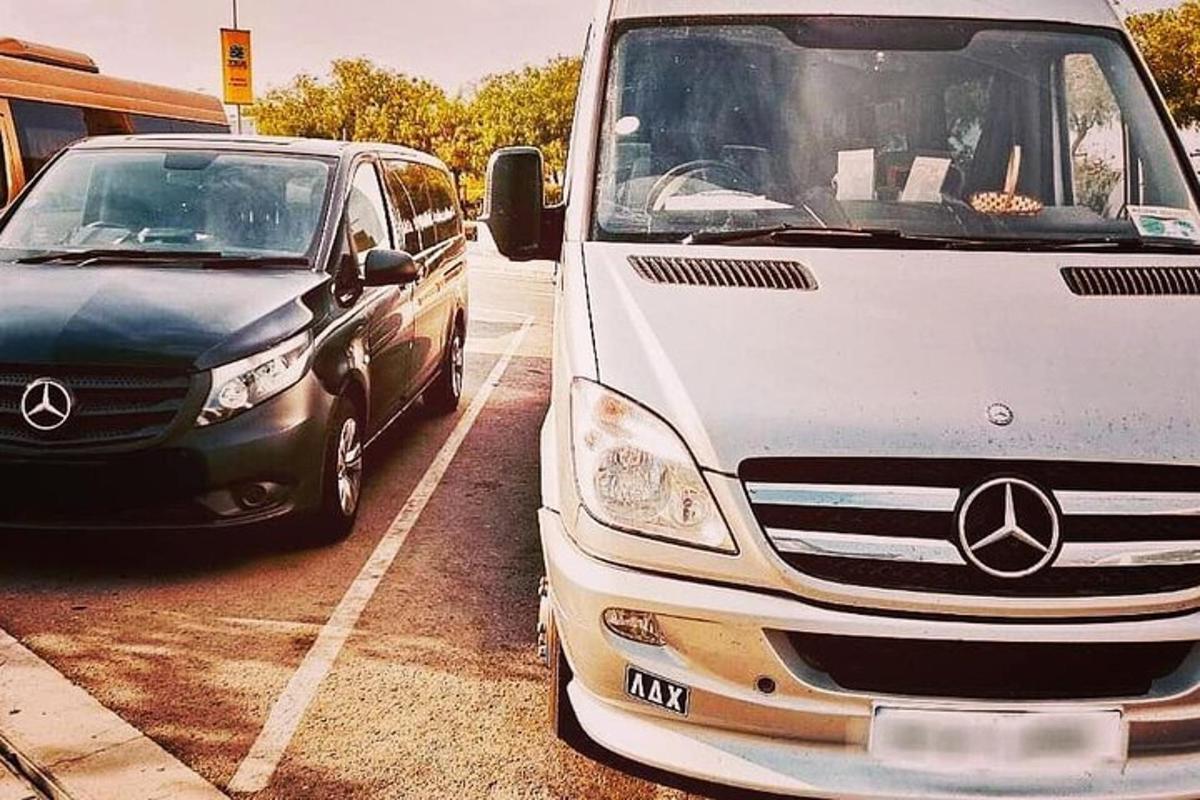 uma van branca e um carro preto estacionados em um estacionamento