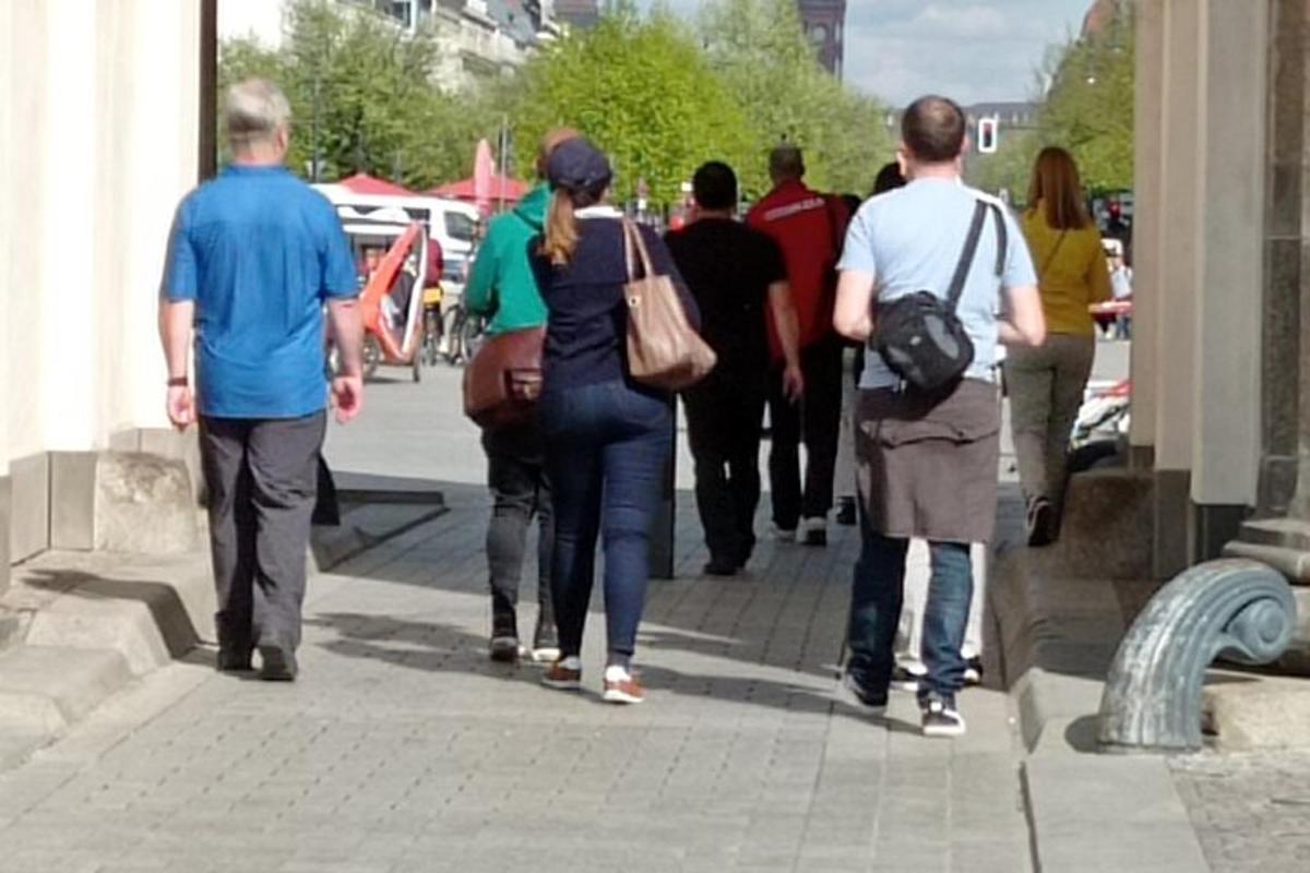 un gruppo di persone che camminano lungo un marciapiede