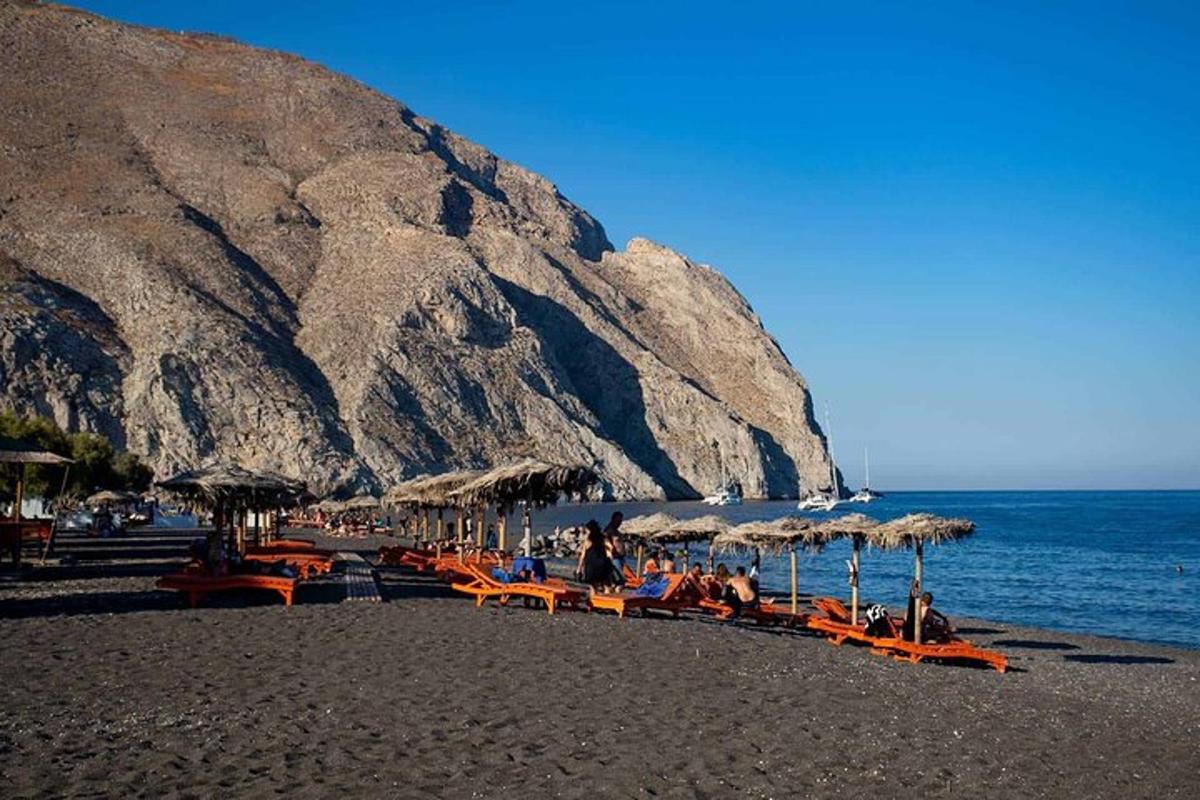 en gruppe mennesker som sitter på en strand med parasoller
