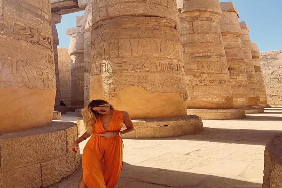 a woman in an orange dress standing in a temple