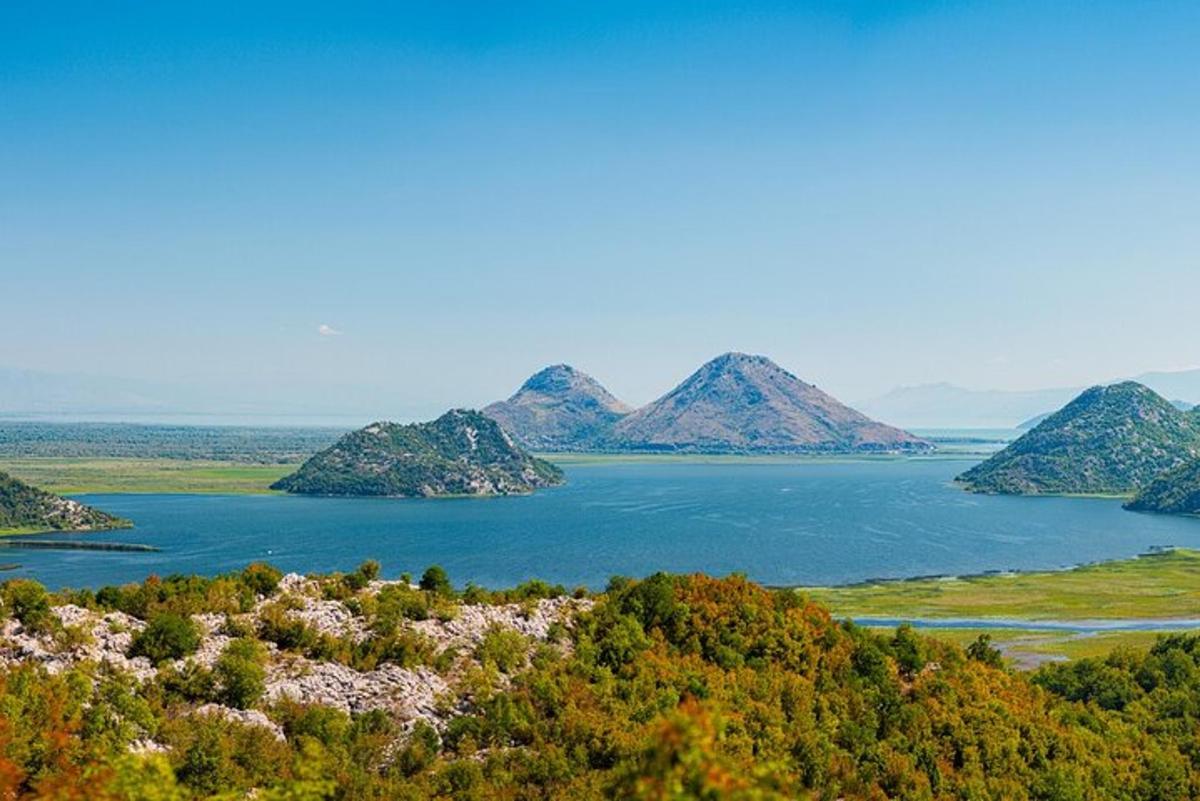 skats uz lielu ūdenstilpni ar kalniem