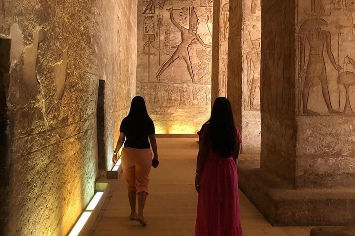 dues dones passejant per un museu amb relleus a les parets