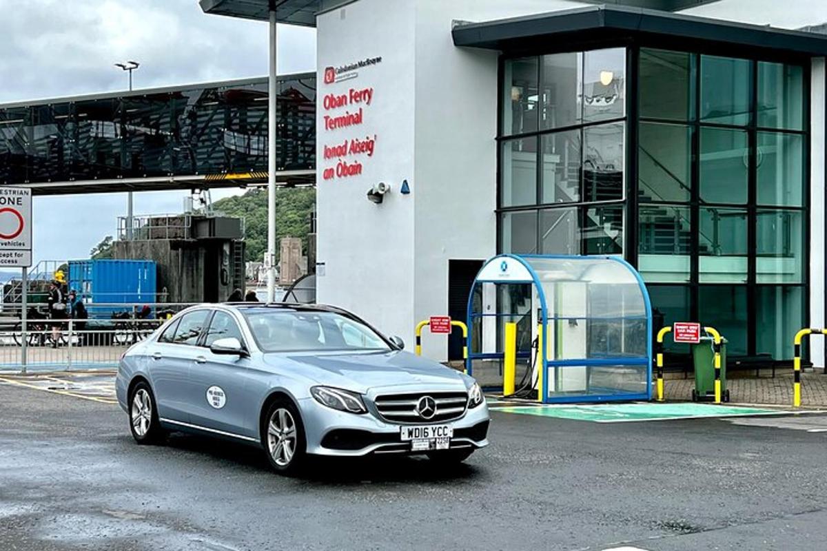 en bil parkert ved siden av en telefonkiosk foran en bygning