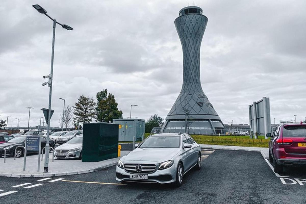 en bil parkert på en parkeringsplass ved siden av et tårn