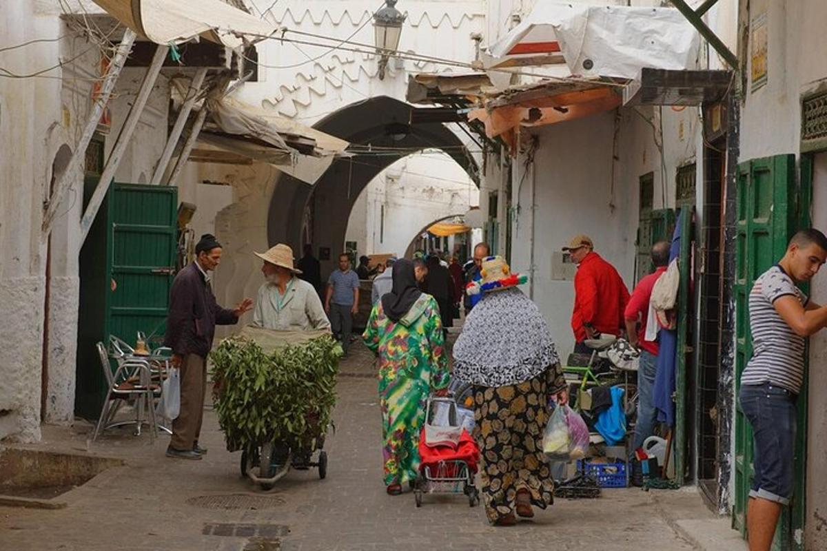 un gruppo di persone che camminano in un mercato in un vicolo