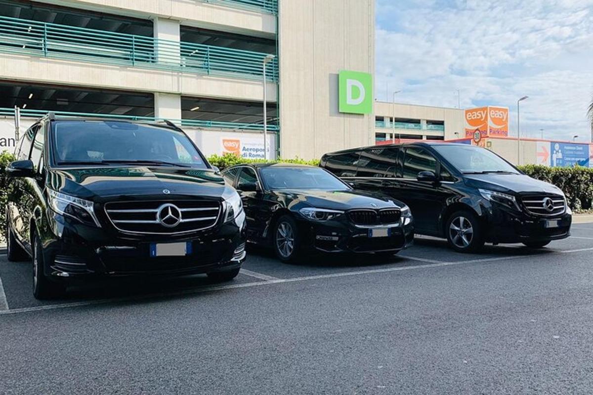 tři auta zaparkovaná na parkovišti před budovou