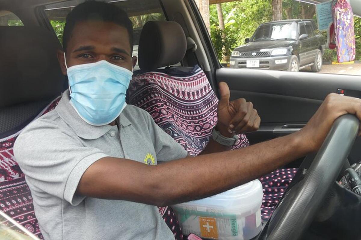 ein Mann mit einer Maske, der in einem Auto sitzt